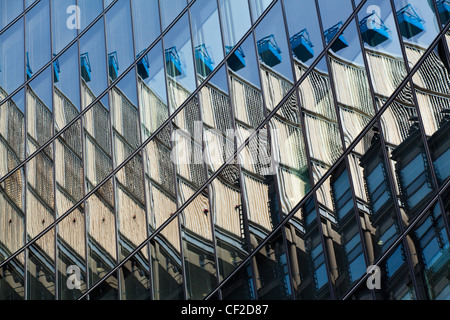 Le bâtiment de la Lloyds se reflète dans le miroir face à des bureaux à proximité pour créer une vue abstraite de l'architecture moderne en f Banque D'Images