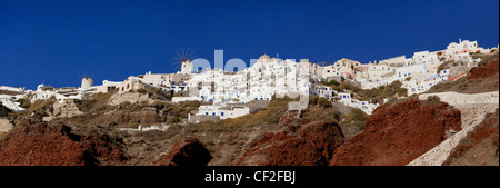 Une vue panoramique sur le village d''Oia et moulin à vent perché sur les falaises rouges au-dessus de la caldera Banque D'Images