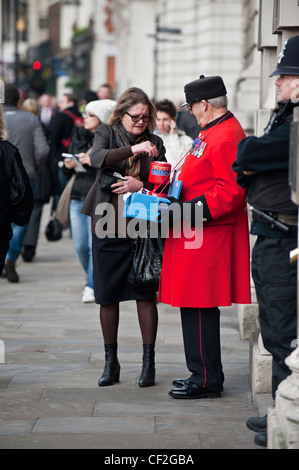 A Chelsea pensionné à recueillir de l'argent pour le Royal British Legion en vendant des coquelicots. Banque D'Images