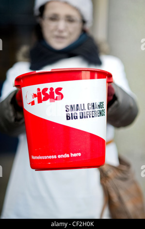 Le changement de perception d'une femme dans un seau pour crise à Noël, l'organisme de bienfaisance national unique pour les sans-abri. Banque D'Images