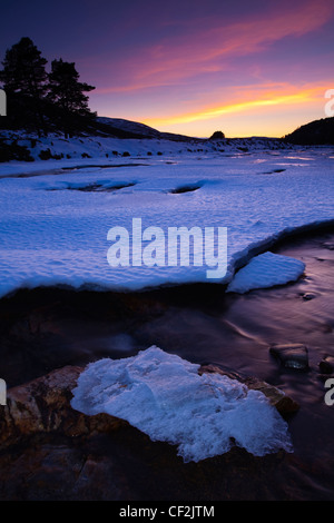 Coucher de soleil rose sur la rivière Dee couvertes de glace près du pont sur la Linn de Dee. Banque D'Images