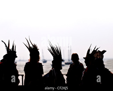 Les membres de la Dark Horse Border Morris Dancers se profilant comme ils ont l'air sur la mer à Leigh-on-Sea. Banque D'Images