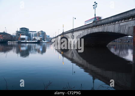 Kew Bridge sur la Tamise, au crépuscule, à la recherche vers un nouvel immeuble d'appartements de luxe (en cours) à Brentford, Londres. Banque D'Images