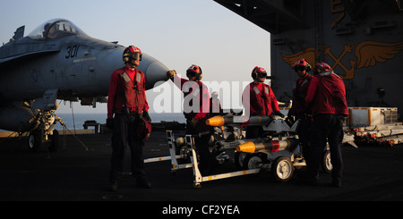 MER D'ARABIE (fév 27, 2012) des militaires de l'aviation attendent de charger un patin de missiles air-air AIM-9 Sidewinder sur un Hornet F/A-18C affecté aux vigilantes de l'escadron de chasse Strike (VFA) 151 sur le pont de vol du porte-avions de la classe Nimitz USS Abraham Lincoln (CVN 72). Abraham Lincoln est déployé dans la zone de responsabilité de la 5e flotte américaine, en effectuant des opérations de sécurité maritime, des efforts de coopération en matière de sécurité dans les théâtres et des missions de soutien dans le cadre de l'opération Enduring Freedom. Banque D'Images