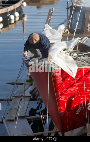 Peinture d'un pêcheur son bateau dans le port de Corrie sur l'île d'Arran. Banque D'Images