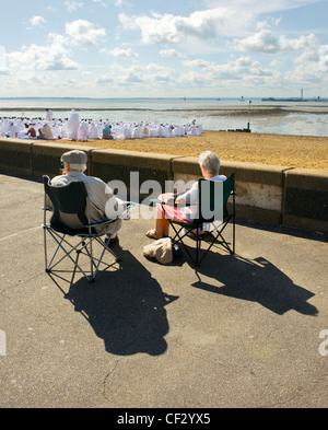 Deux personnes âgées assis dans des chaises sur le front de mer à regarder l'assemblée d'un culte du Jubilé de l'église apostolique sur Bea Banque D'Images