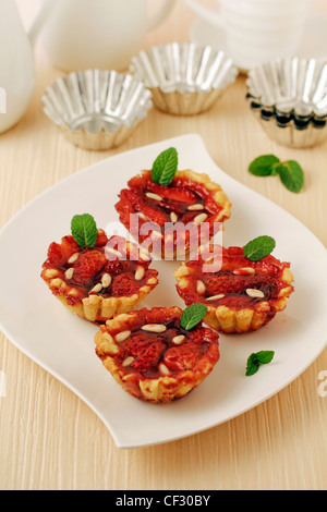 Tartelettes aux fraises avec les pignons de pin. Recette disponible. Banque D'Images