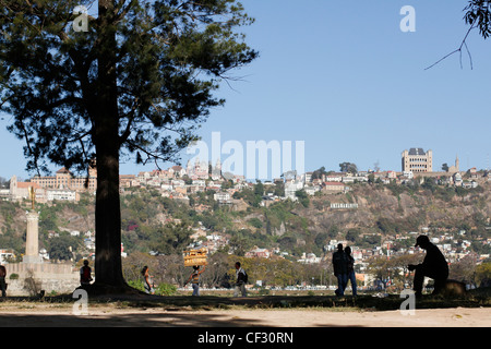 Silhouettes de personnes et vendeur de pain à pied près du lac Anosy dans le centre d'Antananarivo. Madagascar. Banque D'Images