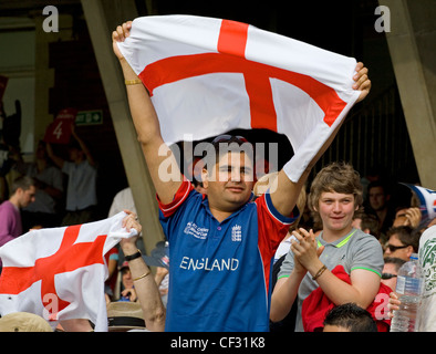 Un fan de cricket Angleterre soutenir son équipe en tenant un drapeau du St George en altitude. Banque D'Images