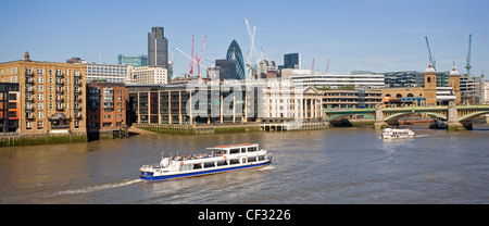 Une vue panoramique sur un bateau se déplaçant le long de la Tamise en direction de Southwark Bridge et de la City de Londres Banque D'Images