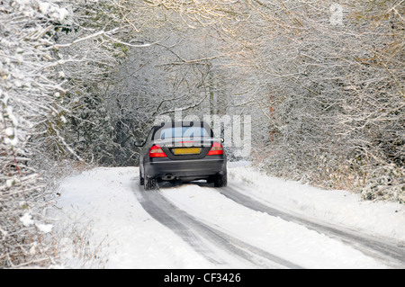 Mercedes Benz CLK 200 coupé cabriolet roulant le long de la neige a couvert country lane (obscurci) plaque Banque D'Images