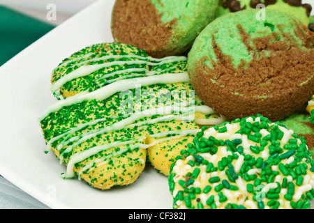 Saint Patrick's Day cookies avec sprinkles vert, vert de la pâte, et d'un cookie sur le sucre en forme de trèfle une plaque blanche Banque D'Images