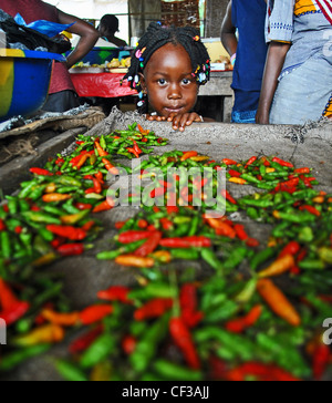 Une jeune fille se penche sur les piments dans un marché à Kenema, Sierra Leone Banque D'Images