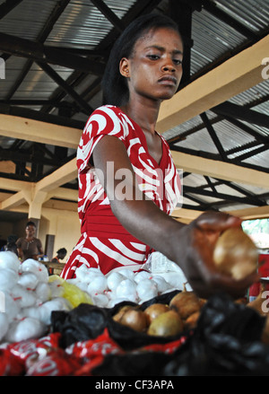 Une femme achète des légumes dans un marché couvert à Kenema, Sierra Leone Banque D'Images