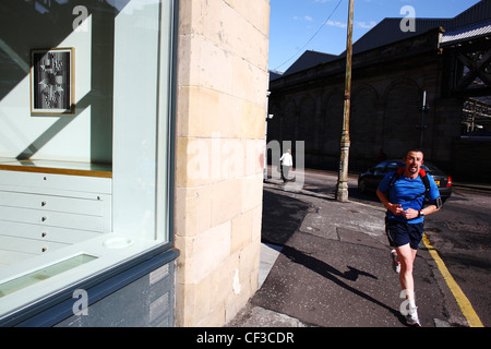 Un coureur passant Ingleby Gallery sur Calton road. Banque D'Images