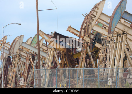 Long Beach en Californie. Rangées de rusty chevalets chevalets de pompage ; ; ; Les ânes signe d'unités de pompage de la pompe de puits de pétrole dans le port. Banque D'Images