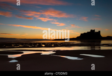 Une vue sur la silhouette de Château de Bamburgh, à l'aube. Le château est assis sur un affleurement de basalte sur le bord de la mer du Nord à un Bamburgh Banque D'Images