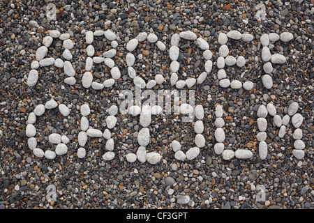 Plage, lettres de l'alphabet fait de pierres blanches sur noir de cailloux. Premier semestre Banque D'Images