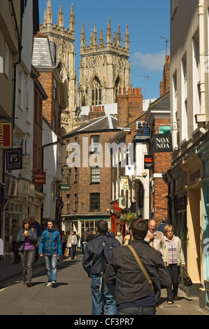 Les visiteurs et clients dans Low Petergate, une petite rue pleine de boutiques et restaurants menant à York Minster. Banque D'Images