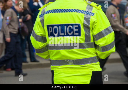 Vue arrière d'un policier en service portant une veste fluorescente lors de l'Assemblée Saint George's Day Parade. Banque D'Images
