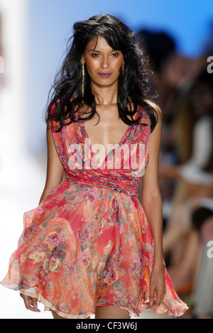 Esteban Cortez New York Prêt à porter printemps été longue brunette portant des cheveux longs d'oreilles en or et rouge florale Banque D'Images