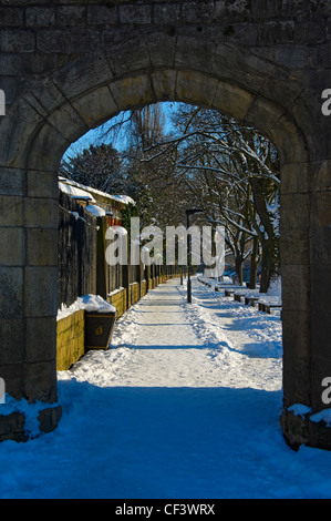 Voir à travers un arc le long du chemin couvert de neige par la rivière Ouse. Banque D'Images