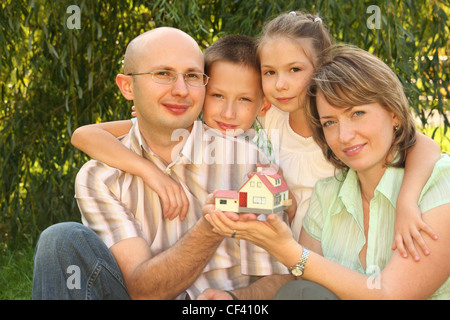 Famille avec deux enfants garder wendy house dans leurs mains Banque D'Images