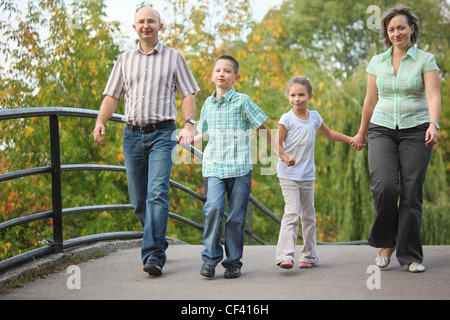 Famille avec deux enfants de marcher sur le pont au début de l'automne parc. famille est handies. se concentrer sur little boy Banque D'Images