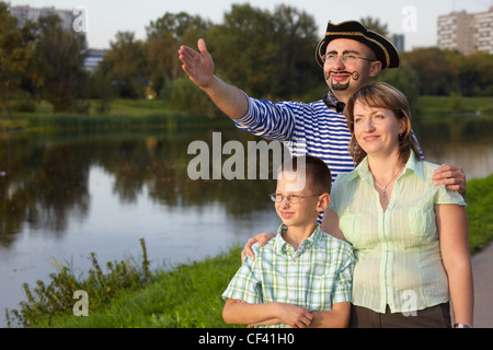 Soirée d'automne en famille park près de l'étang : homme en costume de pirate, femme et petit garçon. l'homme n'est point Banque D'Images