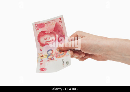 100 yuan chinois un projet de loi avec le portrait de Mao Zedong est tenue à la main, l'arrière-plan blanc. Banque D'Images