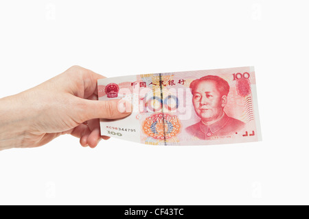 100 yuan chinois un projet de loi avec le portrait de Mao Zedong est tenue à la main, l'arrière-plan blanc. Banque D'Images