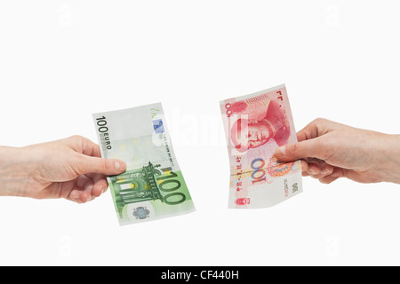 100 yuan chinois un projet de loi est tenue à la main. De l'autre côté une 100 Euro bill est tenue à la main, fond blanc Banque D'Images
