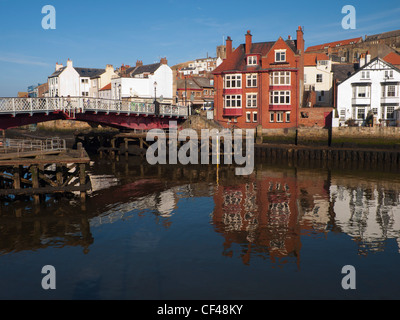 Pont tournant historique de Whitby et le Dolphin Hotel reflète dans la rivière Esk sur une journée de printemps ensoleillée. Banque D'Images