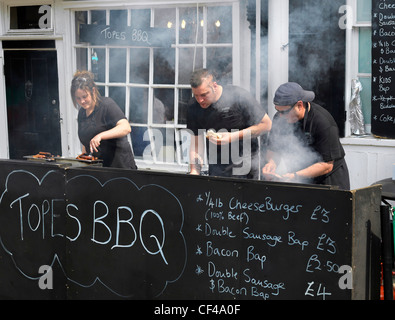 Le personnel de Topes Restaurant la cuisson des aliments sur leur barbecue à la Dickens Festival 2010. Banque D'Images