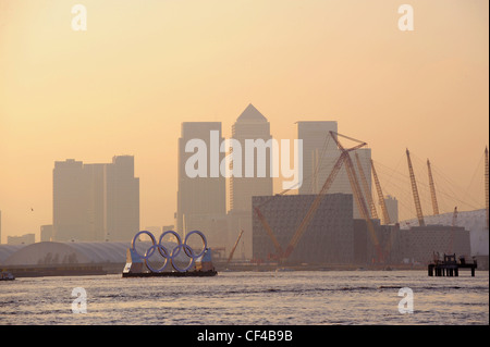 Anneaux Olympiques Londres 2012 voyage dans la ville sur une péniche sur la Tamise. Canary Wharf et l'O2 dans l'arrière-plan. Banque D'Images