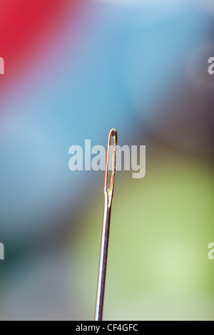 Aiguille à coudre sur un fond coloré. Extrêmement close-up photo Banque D'Images