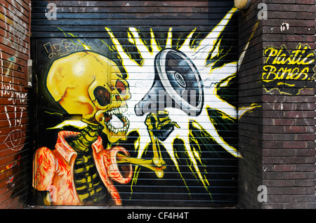 Les os en plastique des graffitis sur un immeuble à Curtain Road dans l'East End de Londres. Banque D'Images