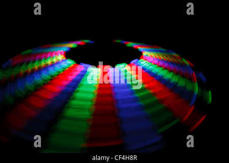 Trace colorée LED rotatif en forme d'un disque sur un fond noir. Banque D'Images
