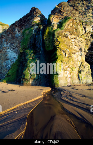 Une petite cascade fonctionne sur de la plage à Runswick Bay dans le Nord du Yorkshire. Banque D'Images