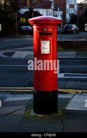 Boite aux lettres rouge classique sur un trottoir à Brighton. Banque D'Images