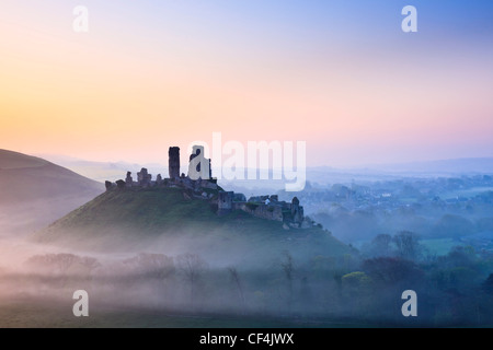 Château de Corfe, remontant au 11e siècle, dans la brume au lever du soleil. Banque D'Images