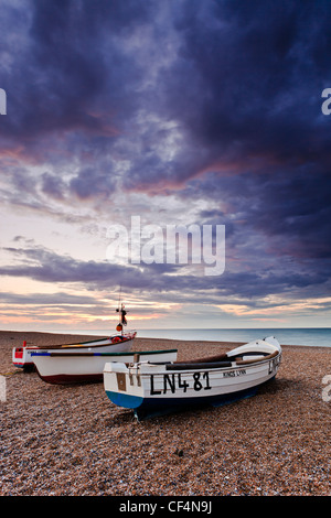 Trois petits bateaux de pêche sur la plage de galets du Claj suivant la mer sur la côte nord du comté de Norfolk. Banque D'Images