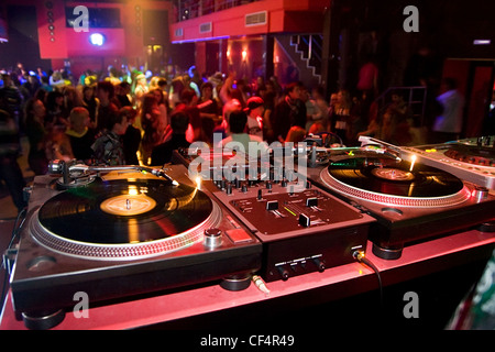 Table dj avec matériel audio dans la foule du club Banque D'Images