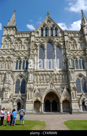 Une famille à l'extérieur de la façade ouest de la cathédrale de Salisbury. Banque D'Images