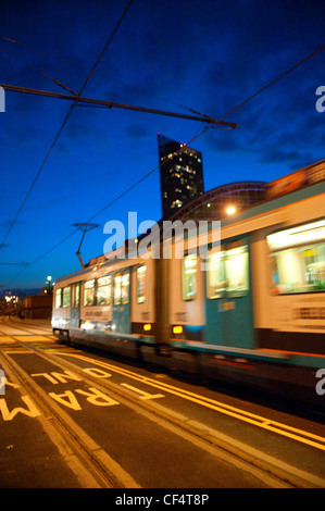 Un arrêt de tramway Metrolink voyageant le long d'une voie à Manchester. Banque D'Images