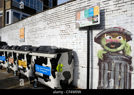 Le Conseil d'Arrondissement de Hackney bacs de recyclage devant un mur peinture murale représentant Sesame Street's Oscar le Grouch. Banque D'Images