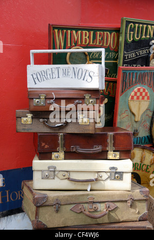 Une pile de vieilles valises en bois et les panneaux publicitaires à l'extérieur d'un magasin d'antiquités de Portobello Road. Banque D'Images