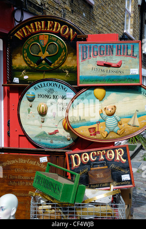 Beaucoup de vieux panneaux publicitaires en bois peint à la main à vendre à l'extérieur d'un magasin d'antiquités de Portobello Road. Banque D'Images