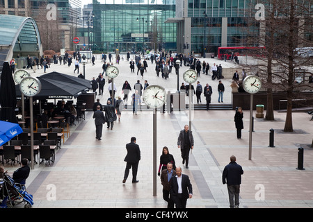 Hommes et femmes d'affaires marche à travers Reuters Plaza passé une série de six horloges double face par Konstantin Grcic, commandé par Banque D'Images