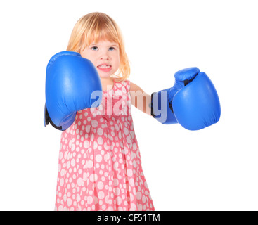 Petite fille aux dents bared portant robe et gants de boxeurs est debout. isolés. Banque D'Images